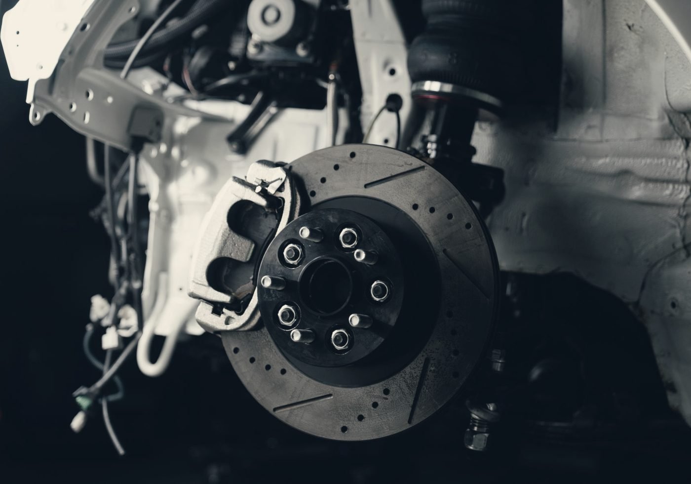 A drilled brake disc and caliper mounted on the hub