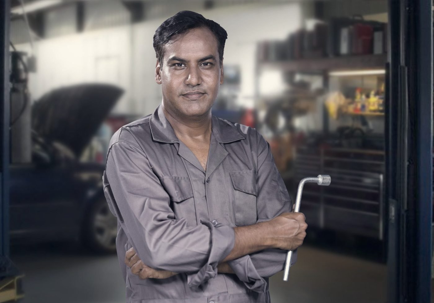 A mechanic with a wrench in his own workshop